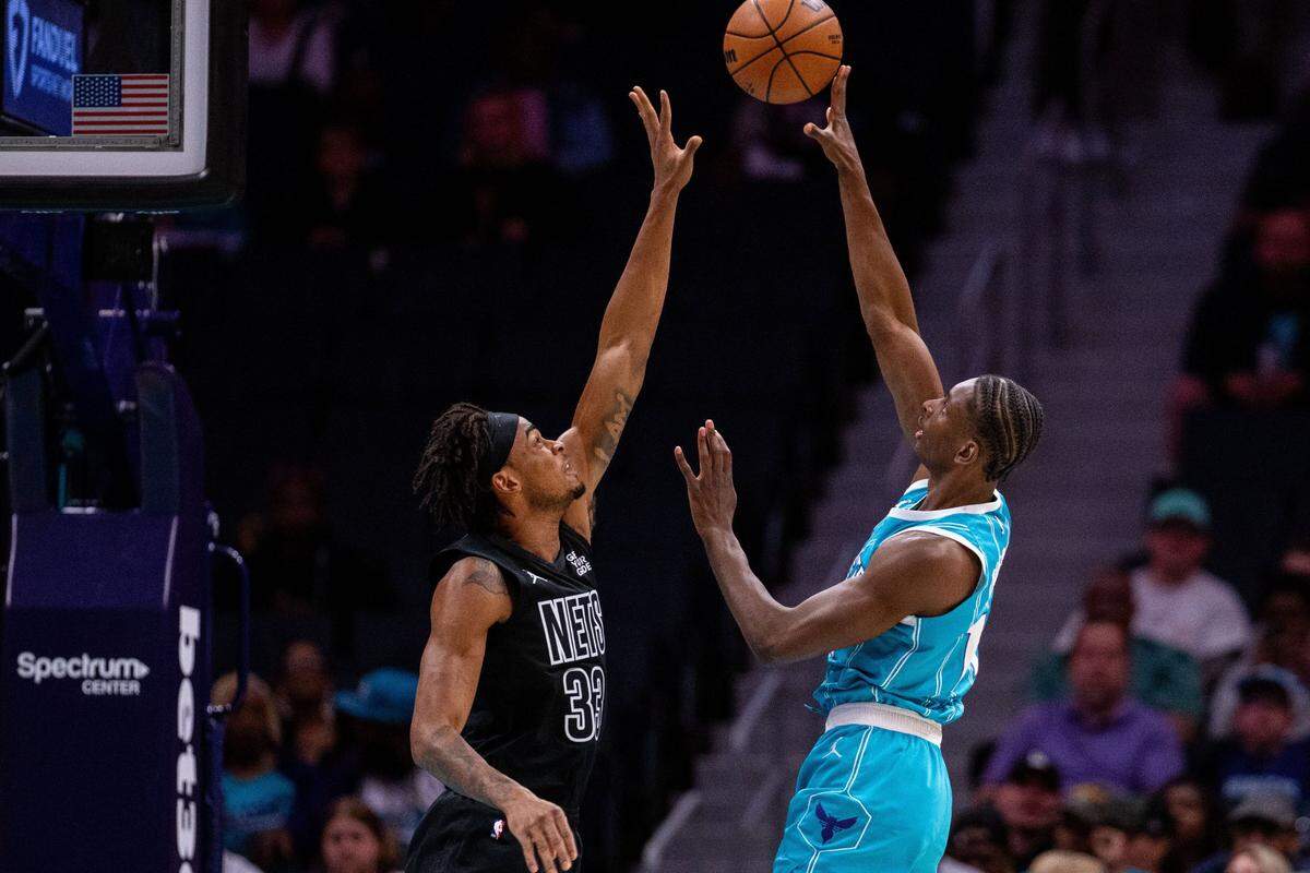 Mar 8, 2025; Charlotte, North Carolina, USA; Charlotte Hornets forward Moussa Diabate (14) shoots on Brooklyn Nets center Nic Claxton (33) during the first quarter at Spectrum Center. Mandatory Credit: Scott Kinser-Imagn Images