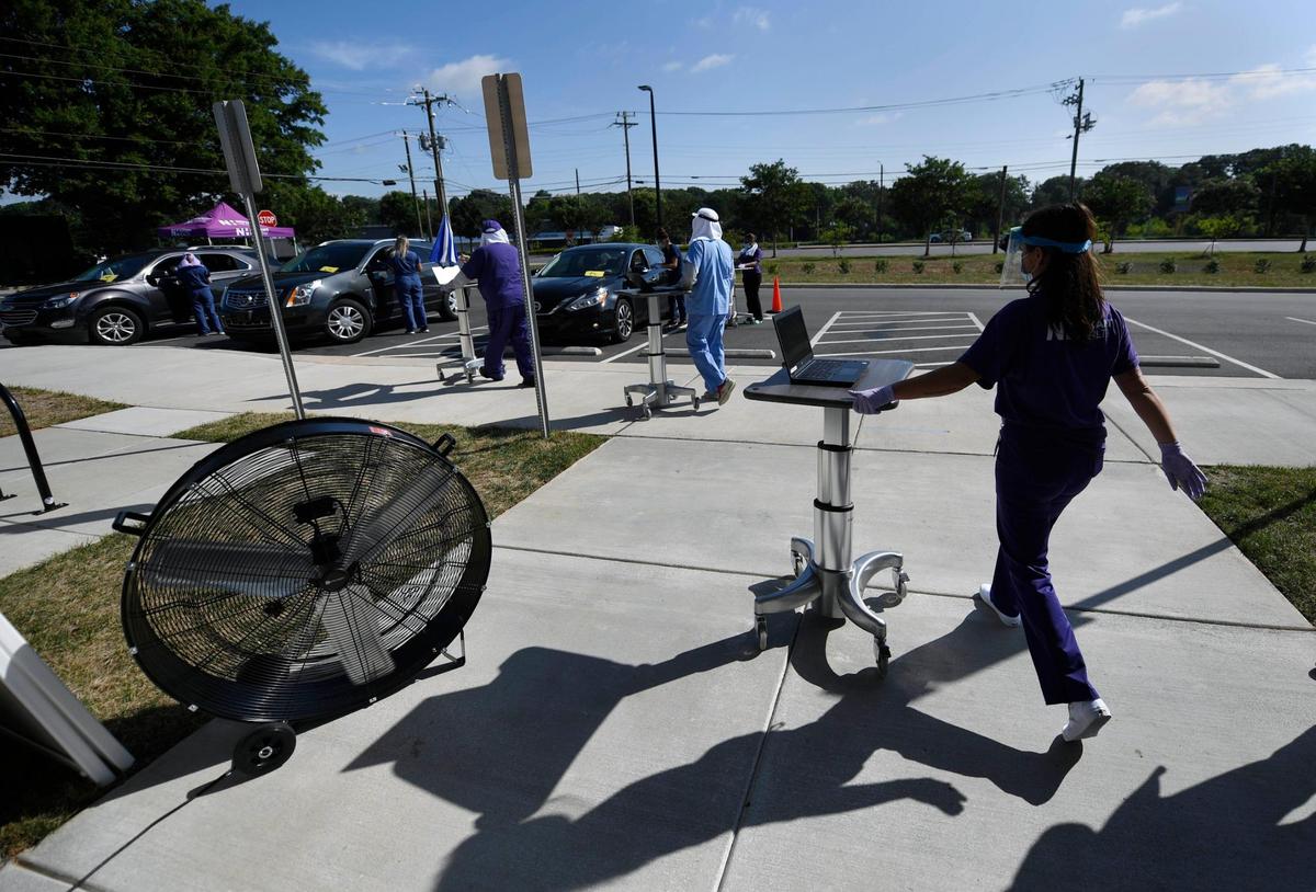 Medical personnel roll out to begin COVID-19 testing of patients waiting in cars in the parking lot at the Michael Jordan Family Medical Clinic in Charlotte on Friday, July 31, 2020.