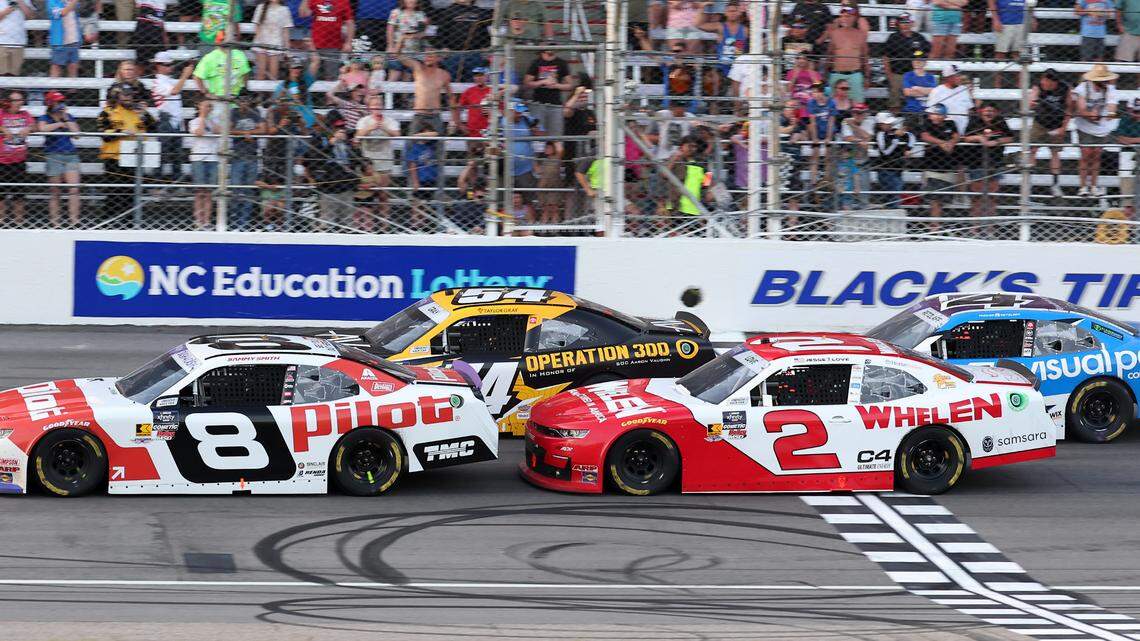 NASCAR driver Sammy Smith, left, leads Jesse Love, right, across the start line on a restart in the closing moments of action in the North Carolina Education Lottery 250 at Rockingham Speedway on Saturday, April 19, 2025. Love was declared the winner of the race only to be disqualified for a suspension violation on his car. Smith has been declared the winner.