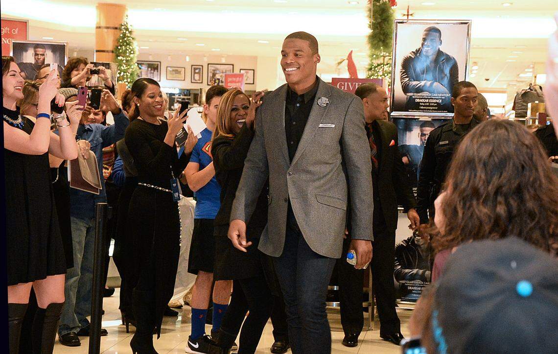 Cam Newton appears to sign bottles of Drakkar Essence for fans in 2014 at Belk at SouthPark.