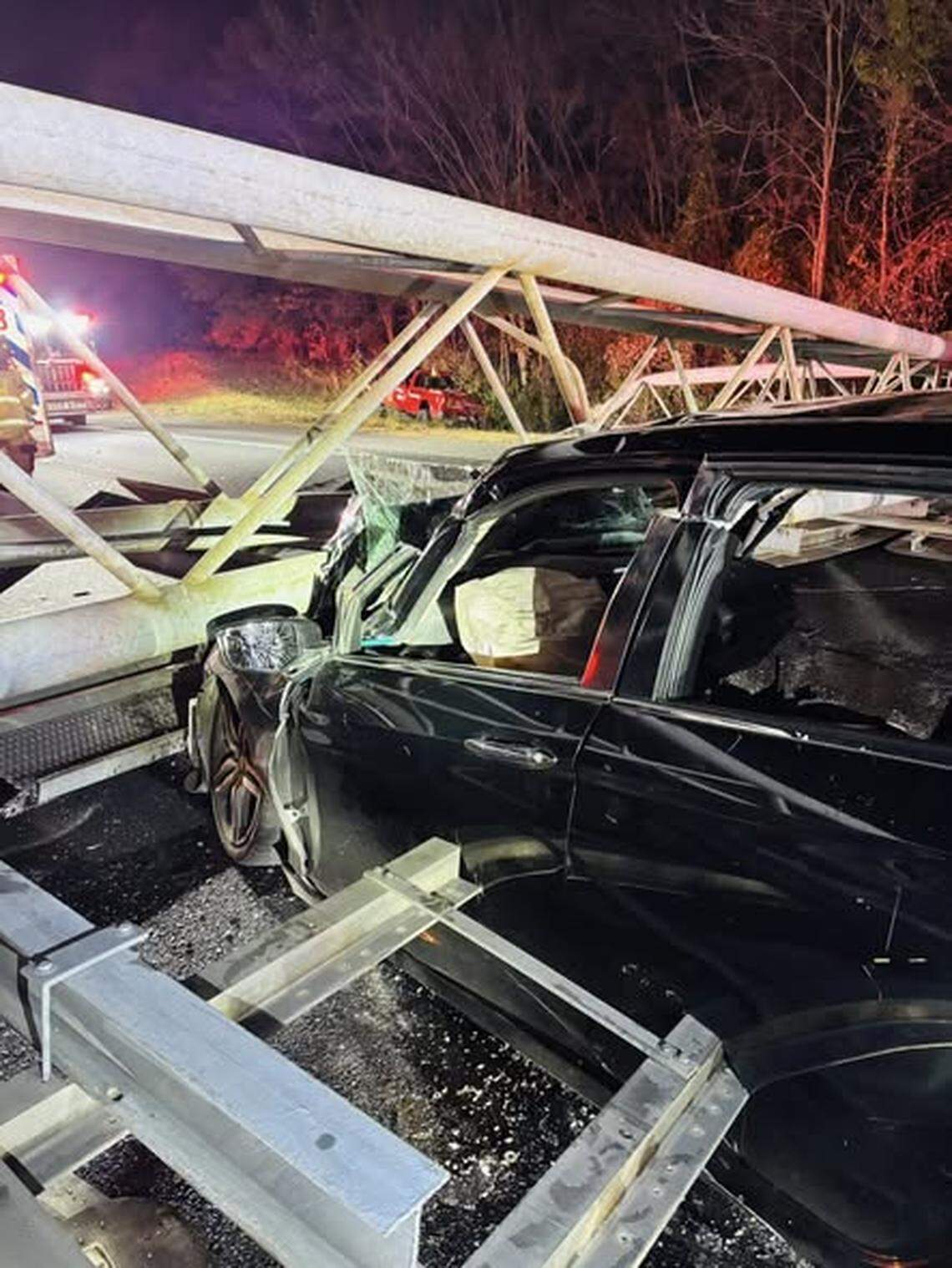 An overhead sign on Interstate 77 collapsed onto a car in Charlotte, trapping the driver and closing the southbound lanes for seven hours late Friday and early Saturday, firefighter