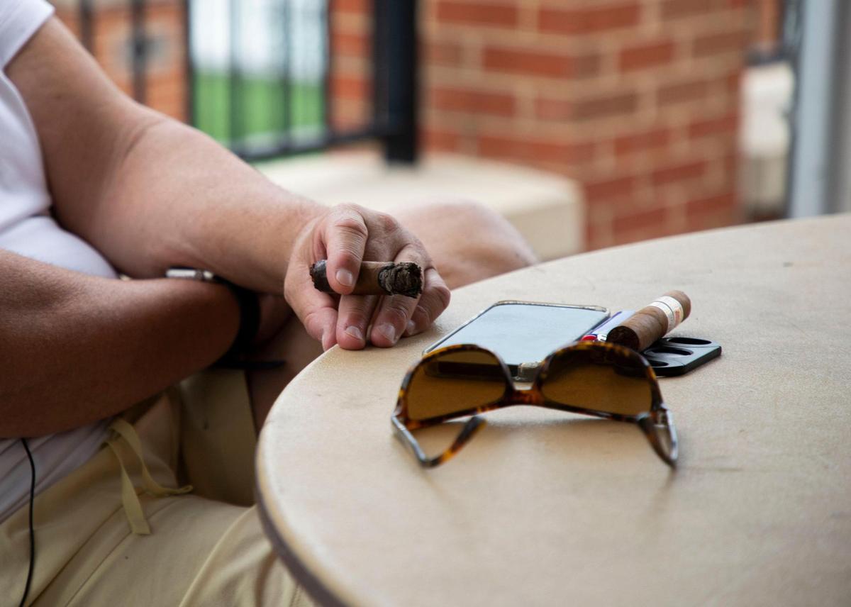 While smoking a cigar, Charlotte 49ers coach Biff Poggi, answers questions from Cameron Williams and Langston Wertz Jr., at Jerry Richardson Stadium for the latest episode of Talking Preps.