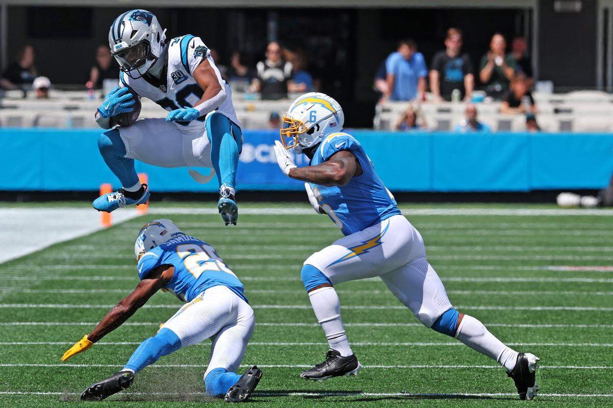 Carolina Panthers running back Chubb Hubbard leaps over Los Angeles Chargers cornerback Asante Samuel Jr., during action on Sunday, September 15, 2024 at Bank of America Stadium in Charlotte, NC.
