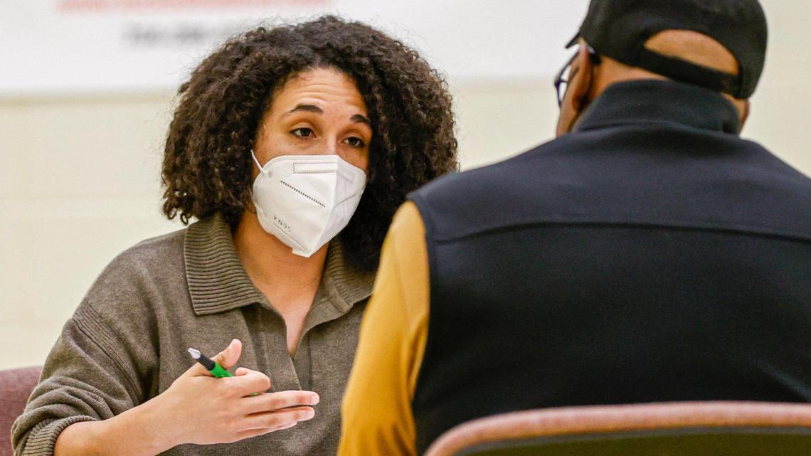 Jaelyn Miller, left, talks to a client as she volunteers at an expungement clinic at Plaza Road Academy in Charlotte, on April 23, 2022.