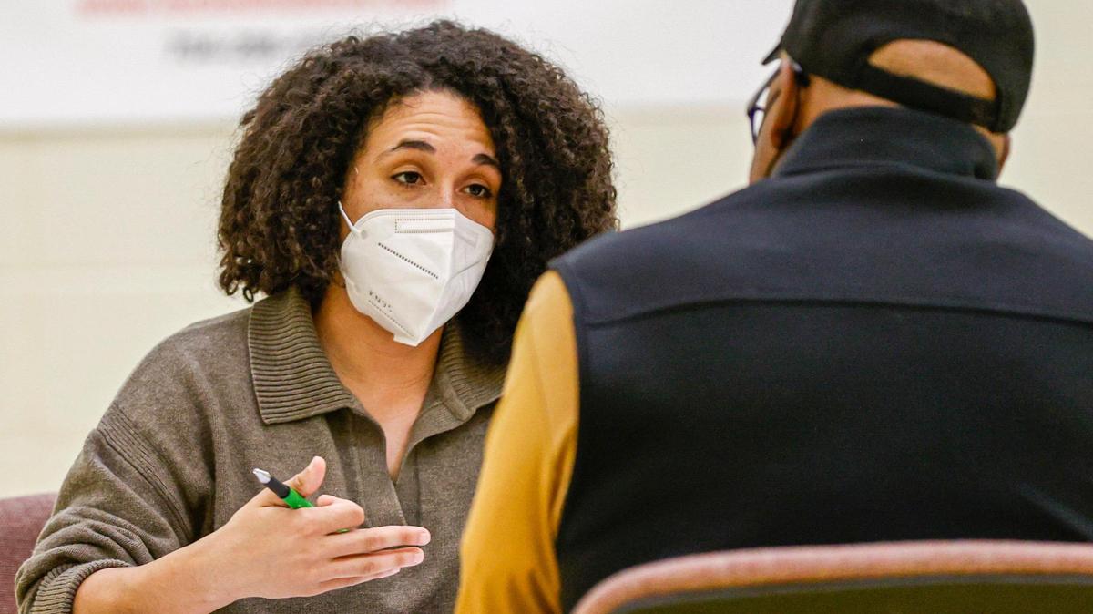 Jaelyn Miller, left, talks to a client as she volunteers at an expungement clinic at Plaza Road Academy in Charlotte, on April 23, 2022.