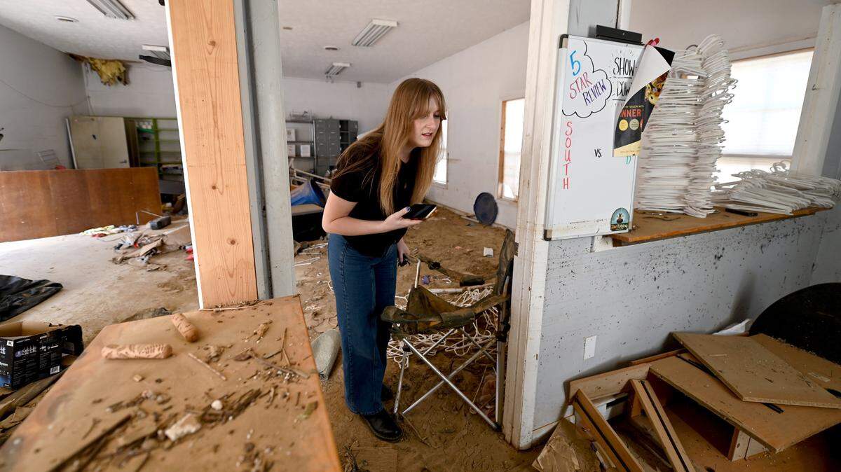 Sarah Schwindt, administrative manager for Zen Tubing in Asheville, NC peers into an office area at the store’s location near the French Broad River on Wednesday, February 5, 2025. River-side businesses are desperate to get out on the water, but Hurricane Helene’s damage was more than anyone expected. The store occurred in late September 2024. Zen Tubing will be operating from a second site this season.