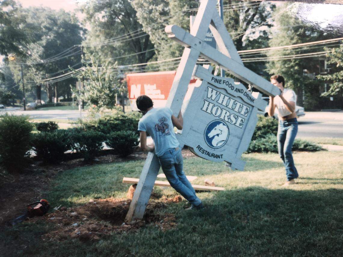 Workers remove The White Horse sign for the switch to 300 East.