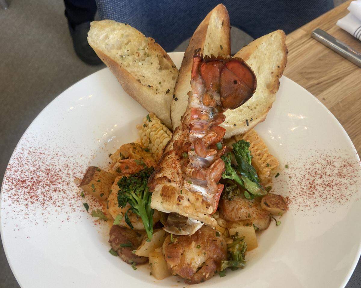 Drift on Lake Wylie’s Lowcountry Boil topped with a lobster tail, with scallops, shrimp, broccolini, potatoes, corn, jalapenos, white wine tomato broth and a toasted baguette.