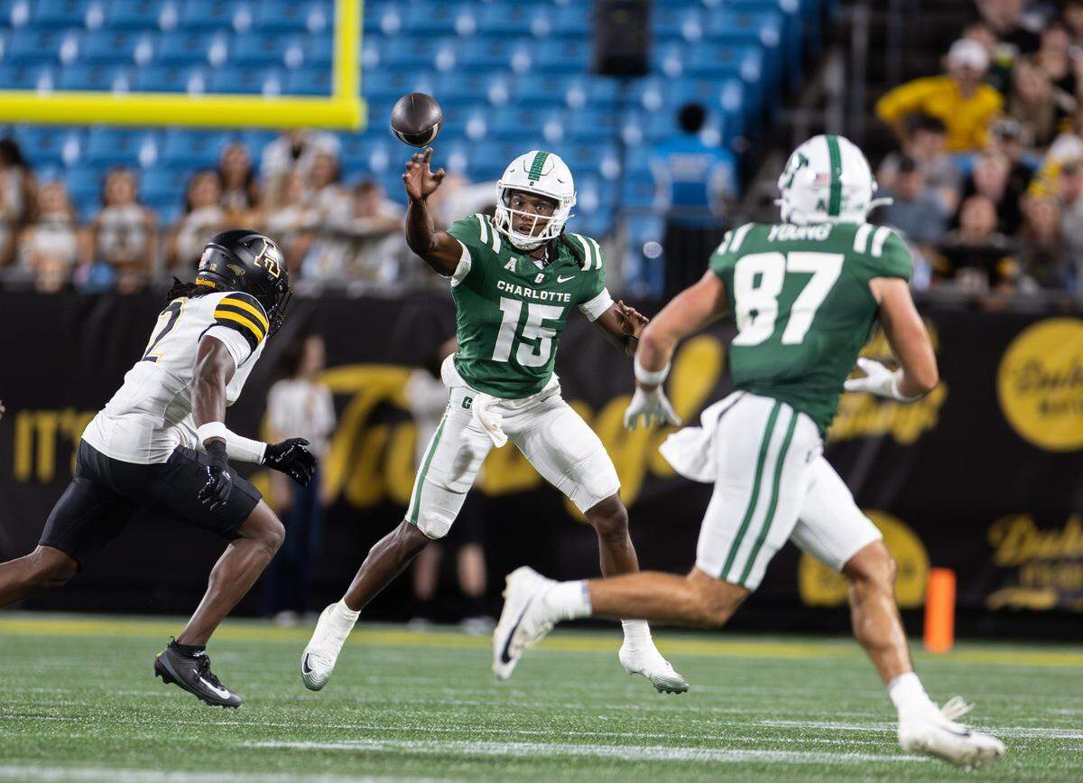 Charlotte 49ers quarterback Conner Harrell, center, makes a pass intended for Charlotte 49ers tight end Jake Young during the Duke's Mayo Classic at the Bank of America Stadium in Charlotte, N.C., on Friday, August 29, 2025.