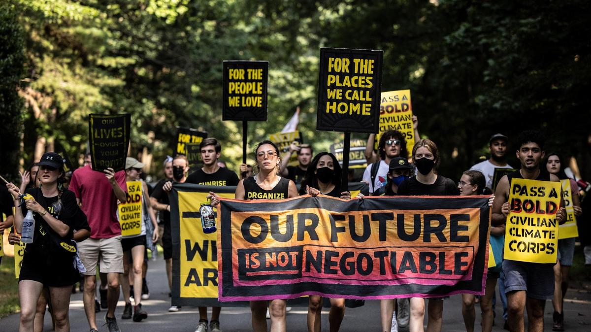 Protesters march down the street during a protest organized by the Sunrise Movement.