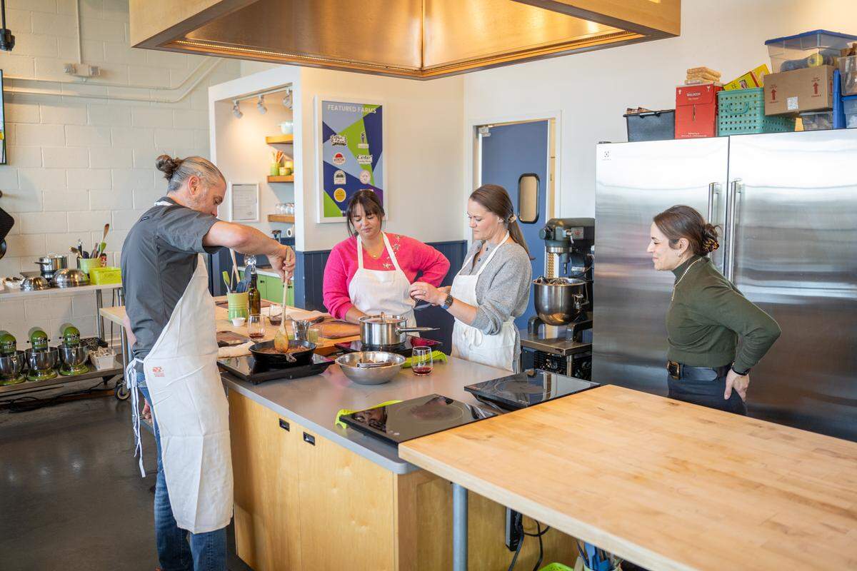 Owner of Chef Alyssa’s Kitchen, Alyssa Wilen, talks to customers taking a class.