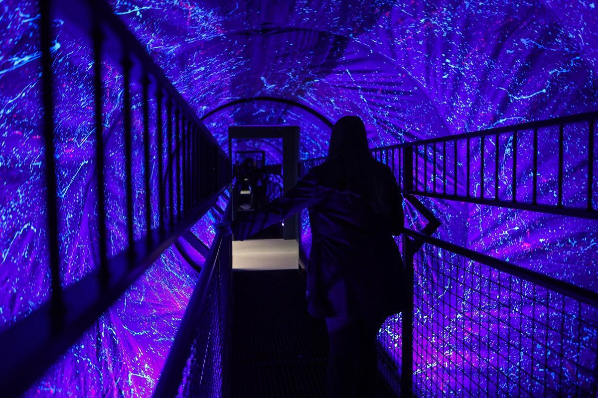 An attendee walks into the vortex room during the Grand Opening Ceremony at Museum of Illusions Charlotte. The room makes it seem nearly impossible for a person to bring their body in balance through the rotating cylinder, despite the fact that they are on a completely stable and flat surface.
