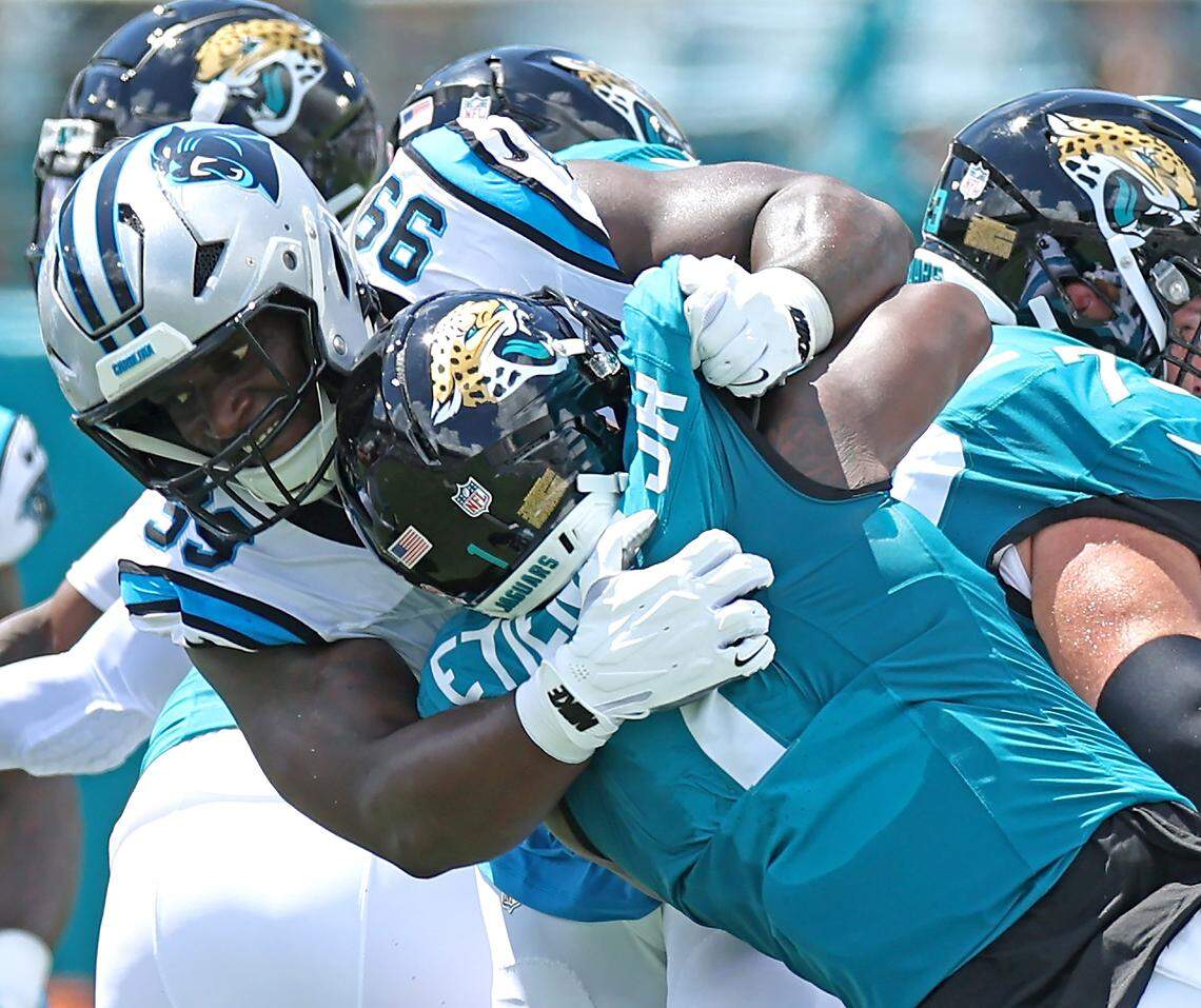 Carolina Panthers defensive tackle Turk Wharton, left, makes the tackle on Jacksonville Jaguars running back Travis Etienne Jr., right, during action on Sunday, September 7, 2025 at Everbank Stadium in Jacksonville, Florida.