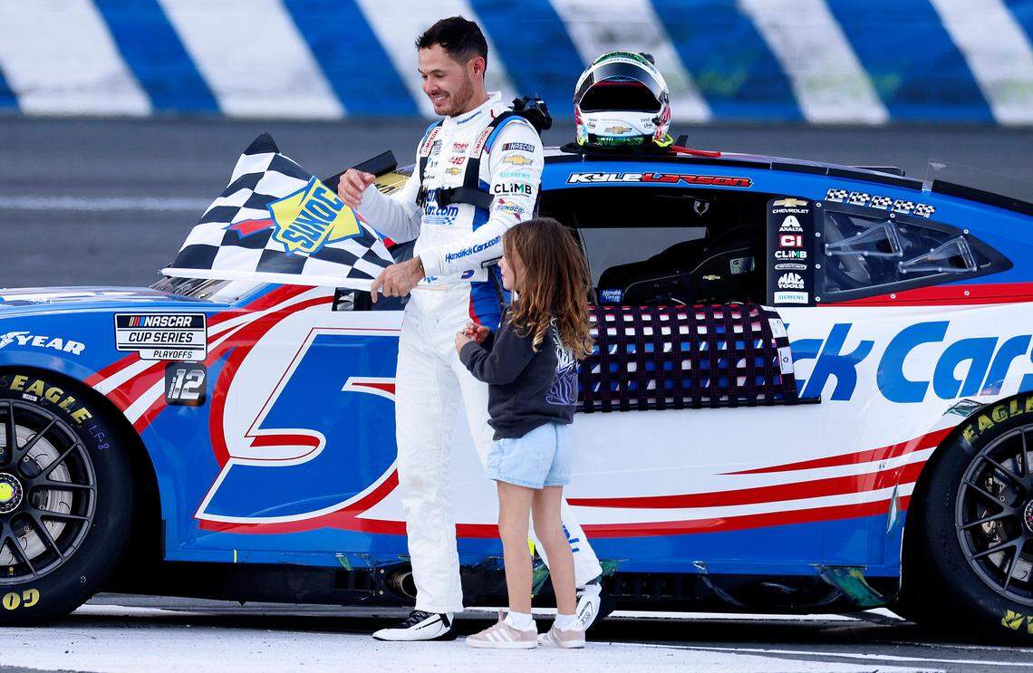 NASCAR driver Kyle Larson, left, celebrates his victory in the Bank of America Roval 400 with his daughter, Audrey, right, at Charlotte Motor Speedway in Concord, NC on Sunday, October 13, 2024.