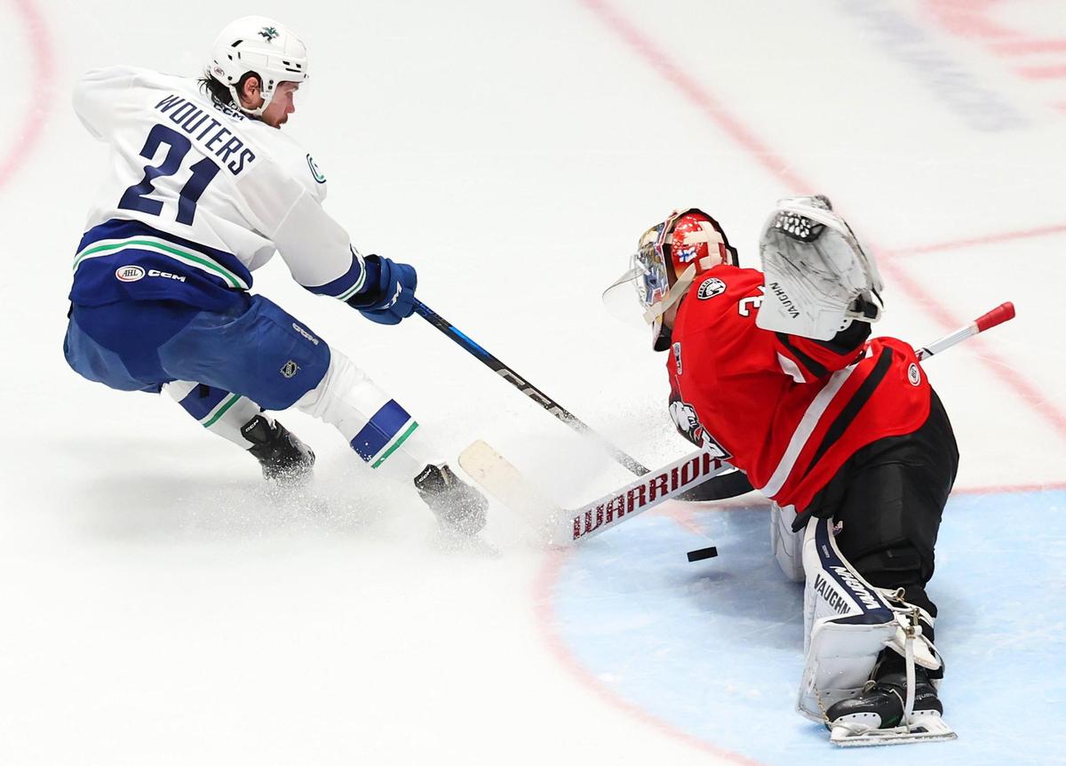 Charlotte Checkers goalie Kaapo Kahkonen, right, stops a shot on goal by Canucks Chase Wouters, left, during action in the Calder Cup on Sunday, June 15, 2025 at Bojangles Coliseum in Charlotte, NC. The series is tied at 1-1.