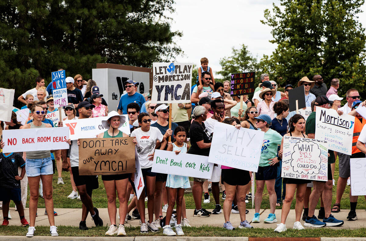 Protesters line the sidewalk to cheer and chant to save the Morrison Family YMCA campus in Ballantyne from the planned sale to Moments of Hope Church on Sunday, July 12, 2026. “This is where we build our lives,” Kim Blades said. “This is where our friends are and where our kids come. It’s just sad.”