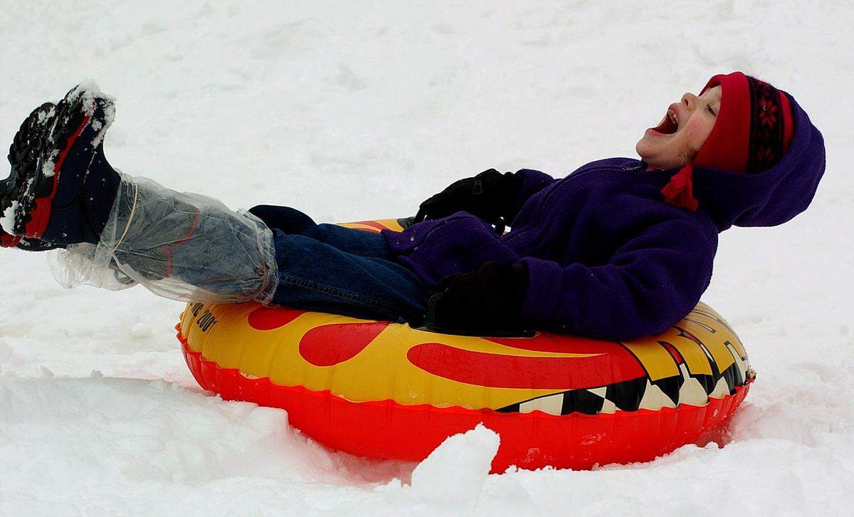 Elizabeth Williams, 6 yrs., kicks up her heels and smiles as she slides down a hill at Mason Wallace Park in Charlotte in February 2004