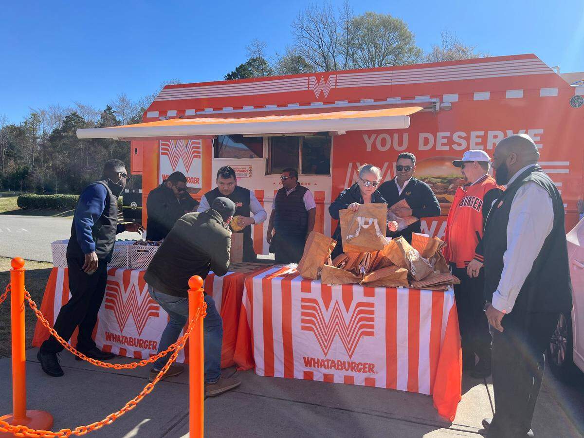 Teachers line up outside Ridge Road Middle School in Charlotte for taste of Whataburger.