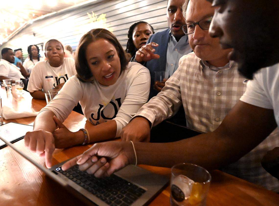 District 3 Charlotte City Council candidate Joi Mayo looks over returns with supporters on Tuesday at Brewers at Yancey. Mayo defeated incumbent Tiawana Brown for the District 3 seat.