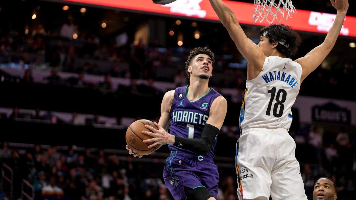 Brooklyn Nets forward Yuta Watanabe (18) defends against Charlotte Hornets guard LaMelo Ball (1) during the first half of an NBA basketball game, Saturday, Dec. 31, 2022, in Charlotte, N.C. (AP Photo/Matt Kelley)