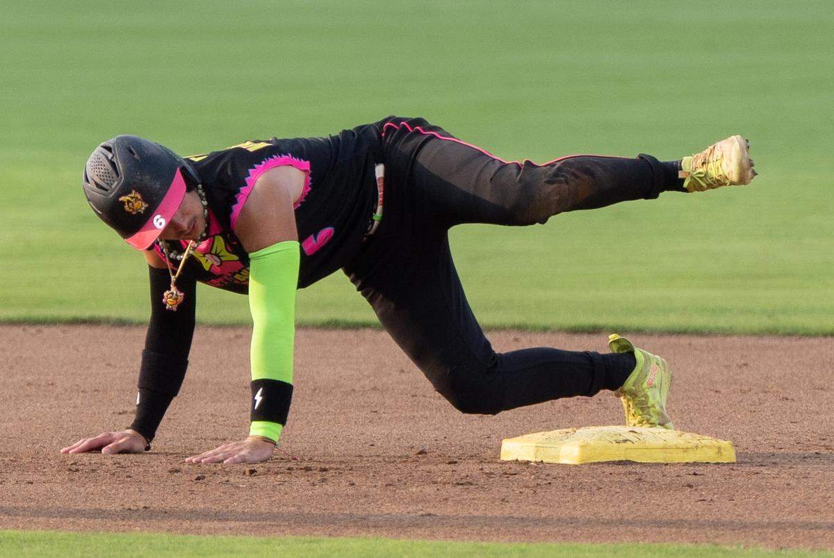 Party Animals Reece Hampton (6) pretends to pee on the base like a dog as Who Lets the Dogs Out plays during their game against the Savannah Bananas on Saturday, Aug. 3, 2024 for their first game of the series at Louisville Slugger Field in Louisville, Ky.