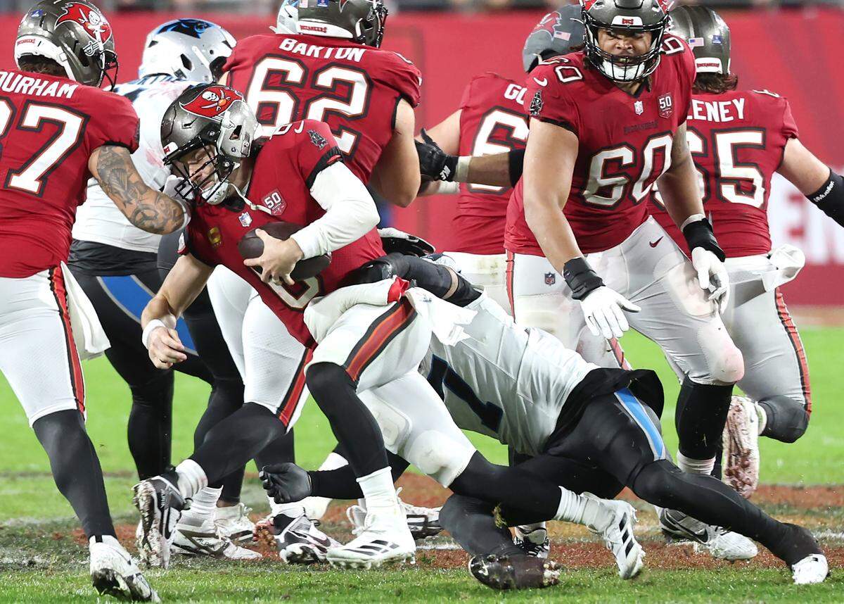 Carolina Panthers safety Tre’von Moehrig, center, sacks Tampa Bay Buccaneers quarterback Baker Mayfield, left, during action at Raymond James Stadium in Tampa, FL.on Saturday, January 3, 2026. The Buccaneers defeated the Panthers 16-14.