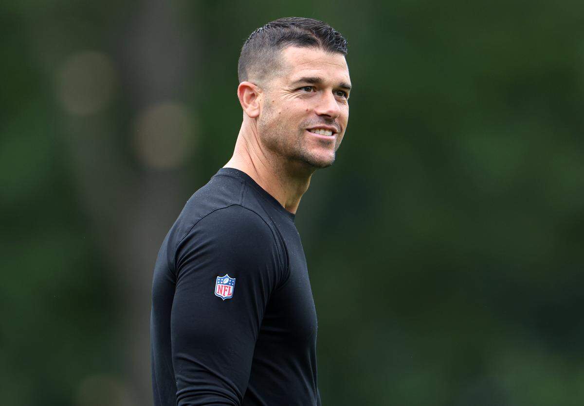 Carolina Panthers head coach Dave Canales glances toward the sidelines as he walks to training camp practice on Thursday, July 25, 2024.