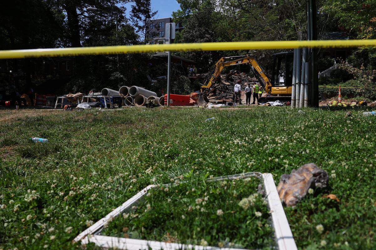 Charlotte Fire Department officials work at the site of a house fire near Freedom Park after an explosion was reported early morning in Charlotte, NC on Friday, May 2, 2025.