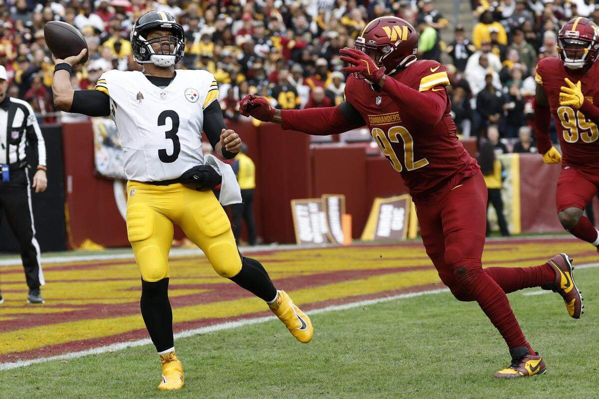 Nov 10, 2024; Landover, Maryland, USA; Pittsburgh Steelers quarterback Russell Wilson (3) passes the ball as Washington Commanders defensive end Clelin Ferrell (99) chases during the first half at Northwest Stadium. Mandatory Credit: Geoff Burke-Imagn Images
