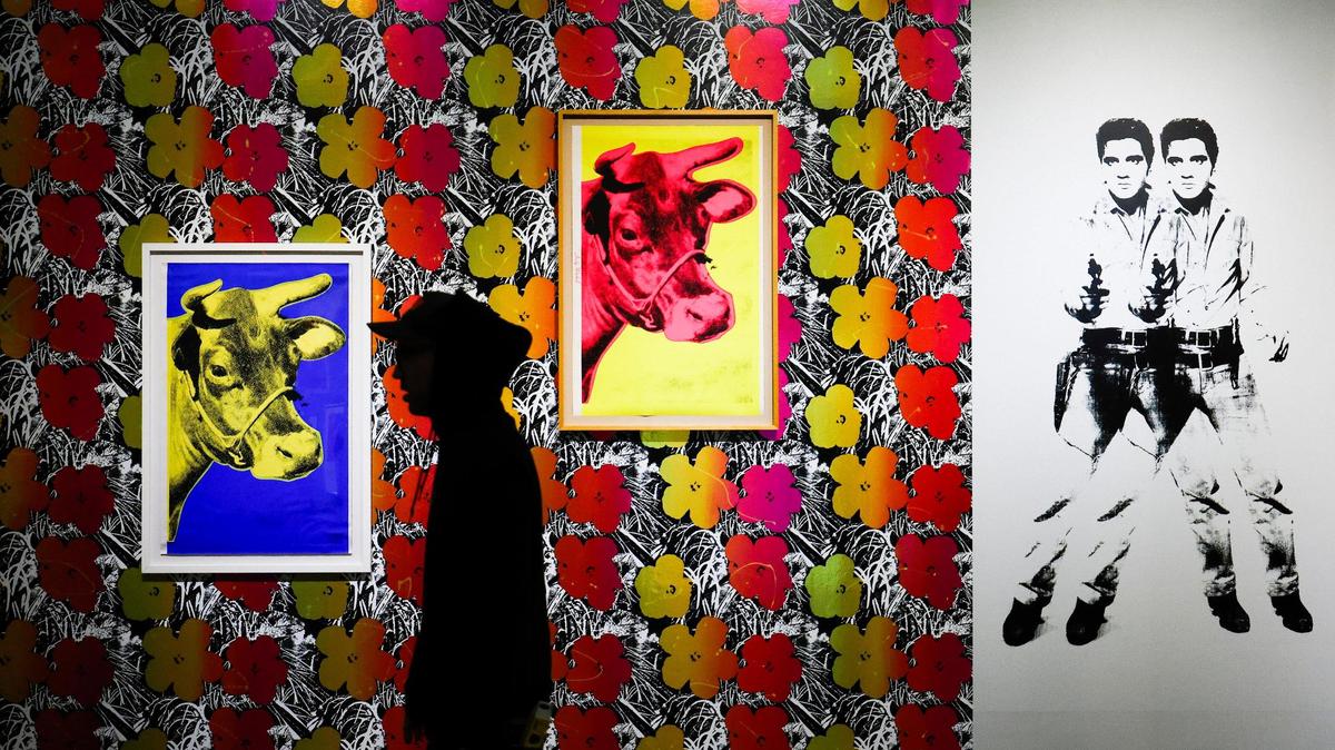 Art handler Clayton Venhuizen passes an Andy Warhol display at the Bechtler Museum of Modern Art in Charlotte. The exhibition titled “Pop to Now: Warhol and His Legacy” runs until Jan. 2.