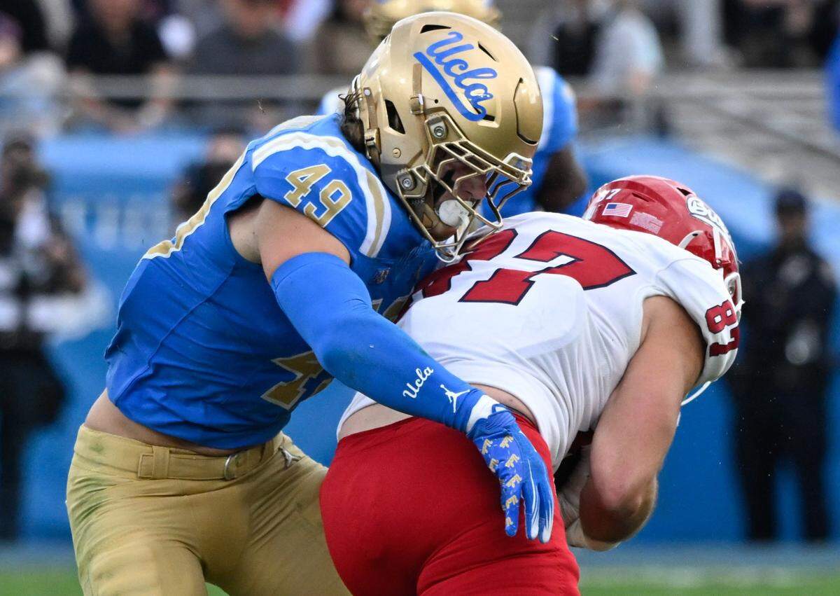 Nov 30, 2024; Pasadena, California, USA; UCLA Bruins linebacker Carson Schwesinger (49) Fresno State Bulldogs tight end Jake Tarwater (87) during the third quarter at Rose Bowl. Mandatory Credit: Robert Hanashiro-Imagn Images