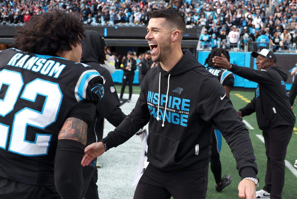 Carolina Panthers head coach Dave Canales, right, reaches out hug safety Lathan Ransom, left, following the team's 23-20 victory over the Tampa Bay Buccaneers on Sunday, December 21, 2025 at Bank of America Stadium in Charlotte, NC. Ransom intercepted a pass by Buccaneers quarterback Baker Mayfield in the final moments of play.
