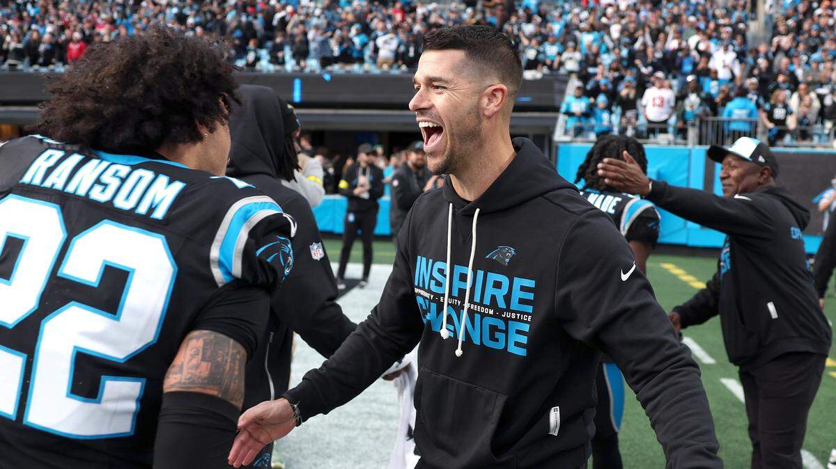 Carolina Panthers head coach Dave Canales, right, reaches out hug safety Lathan Ransom, left, following the team's 23-20 victory over the Tampa Bay Buccaneers on Sunday, December 21, 2025 at Bank of America Stadium in Charlotte, NC. Ransom intercepted a pass by Buccaneers quarterback Baker Mayfield in the final moments of play.