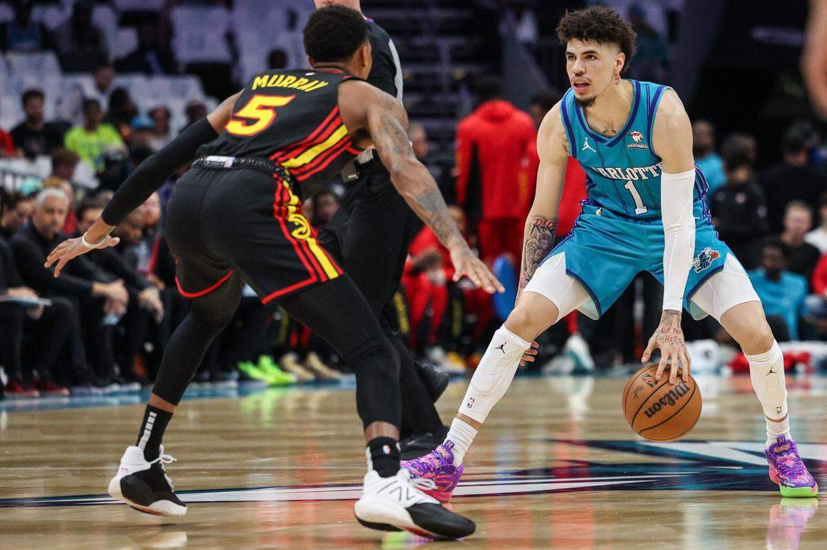 Hornets guard LaMelo Ball, right, dribbles as Hawks guard Dejounte Murray defends during the game at Spectrum Center on Wednesday, October 25, 2023.