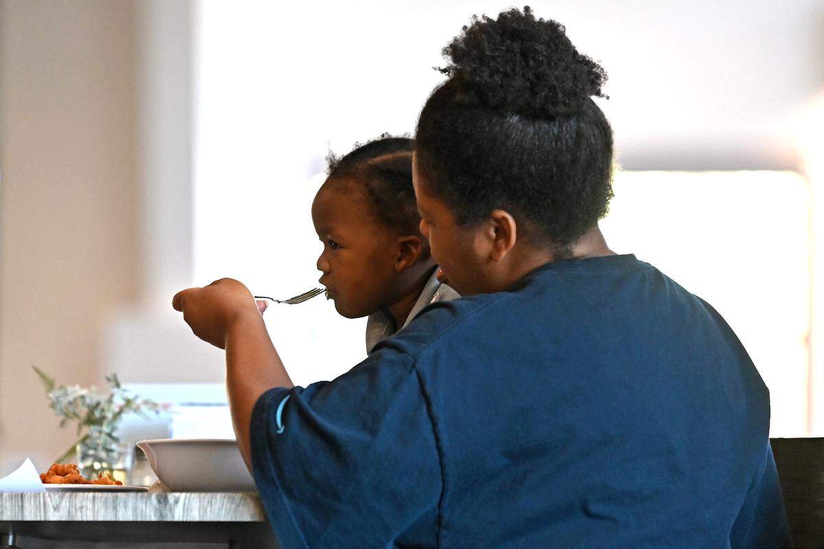 LaTonda Faggart feeds her two-year old son, Ezekiel Faggart during lunch at FeedNC on Tuesday, October 24, 2023. FeedNC formerly known the Mooresville Soup Kitchen relies 100% on community donations to provide breakfast, lunch and groceries to people in need each week day. FeedNC offers culinary and warehouse jobs. The program’s classes are 12-week programs.