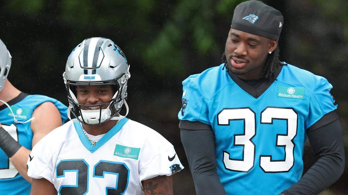 Carolina Panthers running back Trevor Etienne (center) and outside linebacker Princely Umanmielen (right) walk to the team’s OTA practice on Tuesday, May 27, 2025.