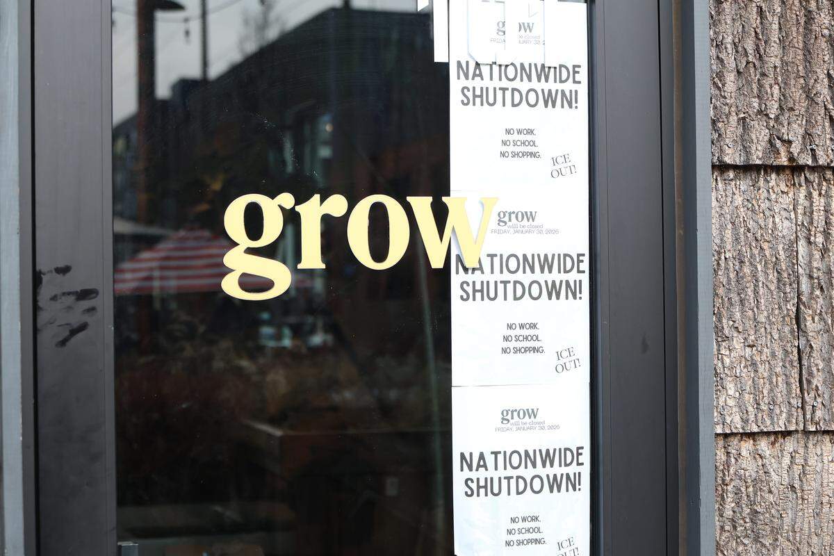 This image shows the storefront of a business named “grow” with several notices posted on the glass door. The flyers prominently display a call for a “NATIONWIDE SHUTDOWN!,” noting it is closed on Friday, January 30, 2026. The flyers advocate for “NO WORK. NO SCHOOL. NO SHOPPING” and carry the phrase “ICE OUT!”