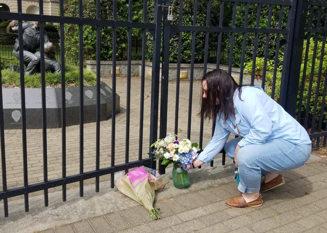 Beca Deal places flowers at a memorial in uptown Charlotte for fallen police officers.