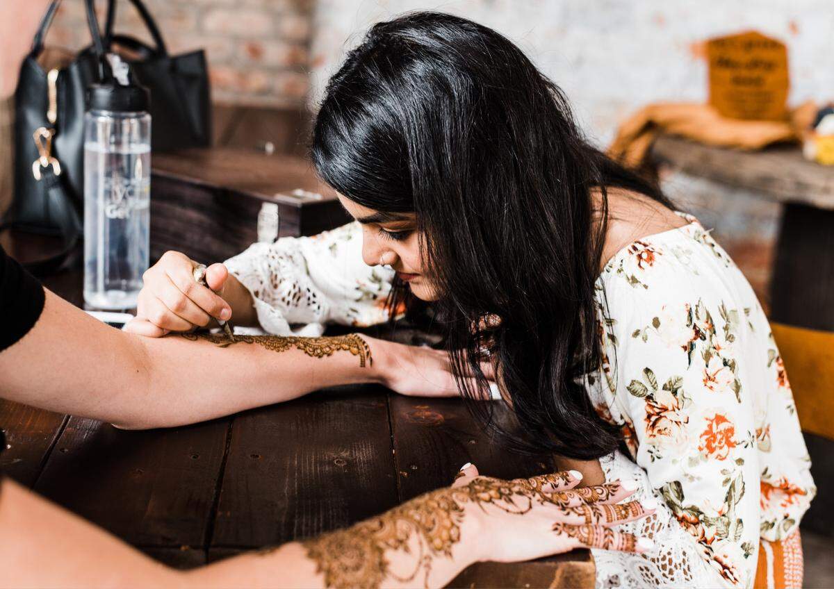 Artist Sana Nisar freestyles a henna design on a client for a wedding photo shoot.