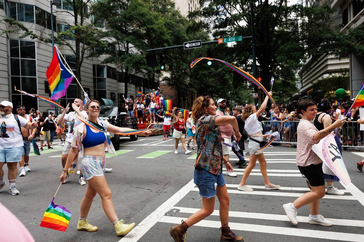 Participants from One Voice Charlotte wave rainbow streamers. One Voice is an LGBTQIA and allies chorus group, working to increase understanding and acceptance of its members during the Charlotte Pride Festival & Parade on Sunday, Aug. 18, 2024