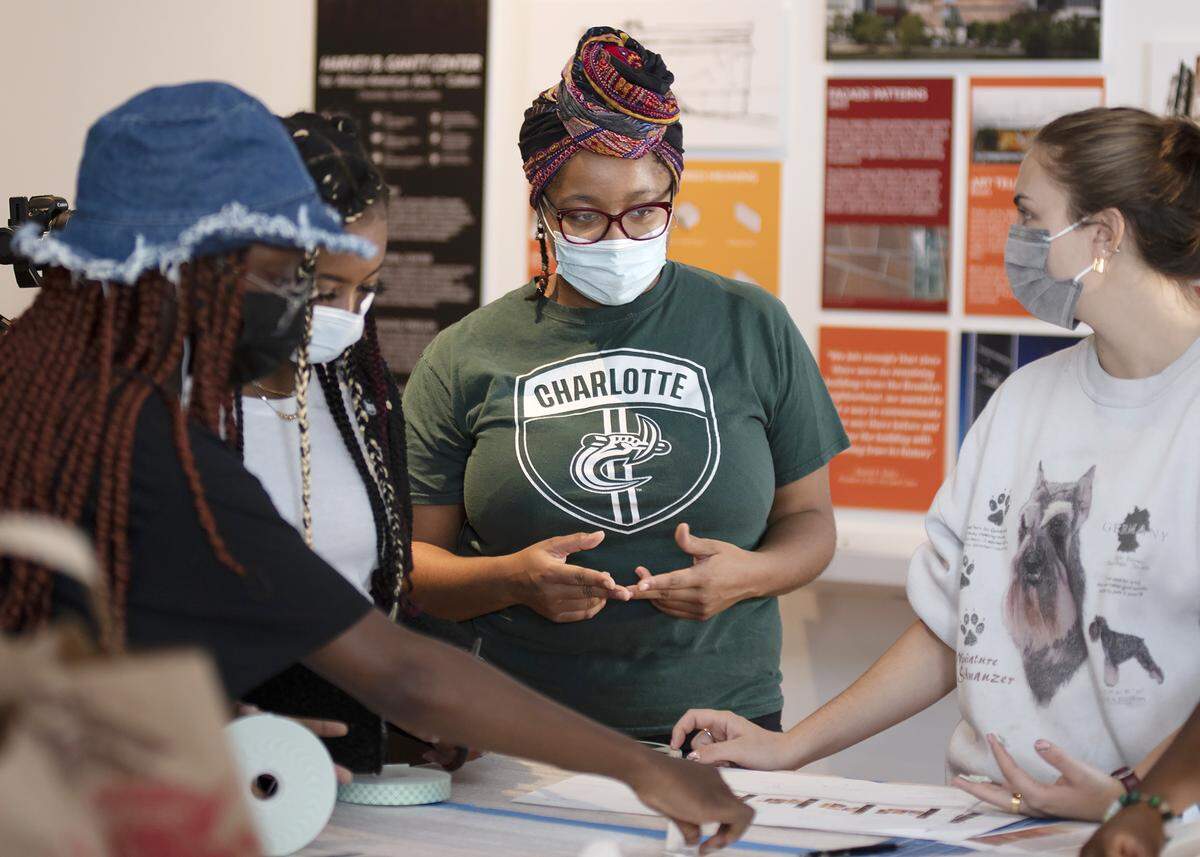 Architecture student Tahlya Mock, center, works with others at the “Container/Contained: Phil Freelon — Design Strategies for Telling African American Stories” exhibit at the Gantt Center.