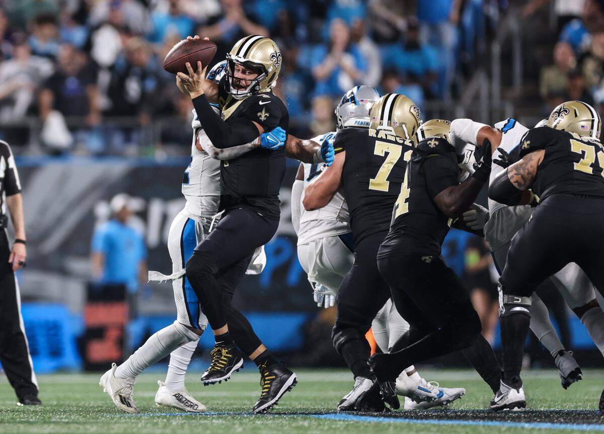 Carolina Panthers linebacker Kamu Grugier-Hill, left, sacks New Orleans Saints quarterback Derek Carr at the Bank of America Stadium in Charlotte, N.C., on Monday, September 18, 2023.