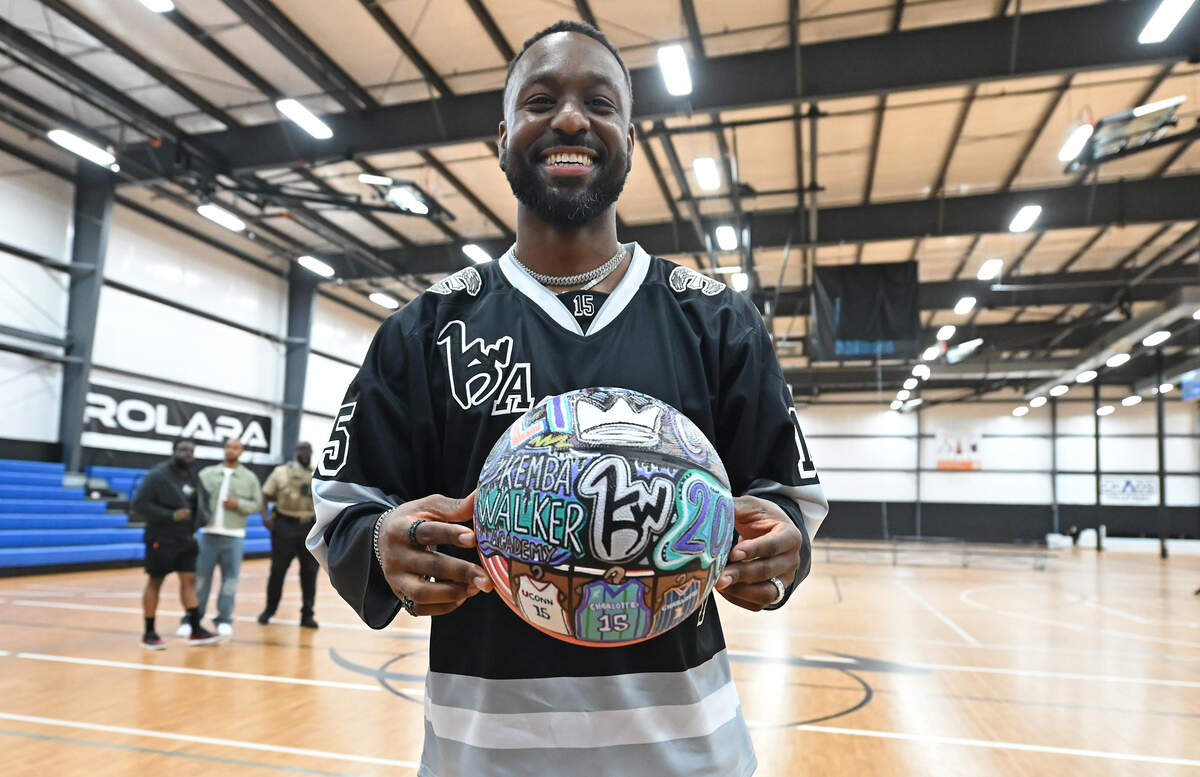 Former Charlotte Hornets guard Kemba Walker proudly holds a decorated basketball given to him from the Palmetto Market in Concord, North Carolina, following a news conference for his new Kemba Walker Sports Academy in Concord on Friday, June 26, 2026.