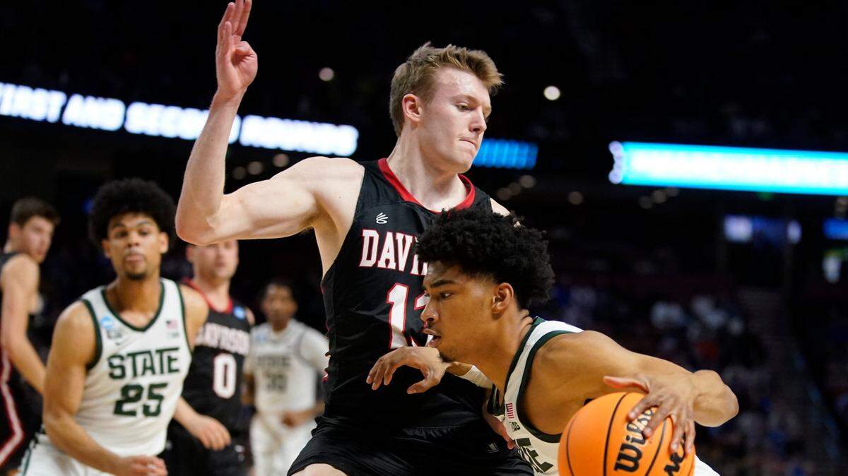 Michigan State guard Jaden Akins drives to the basket past Davidson guard Michael Jones during the second half of a college basketball game in the first round of the NCAA tournament on Friday, March 18, 2022, in Greenville, S.C. (AP Photo/Chris Carlson)