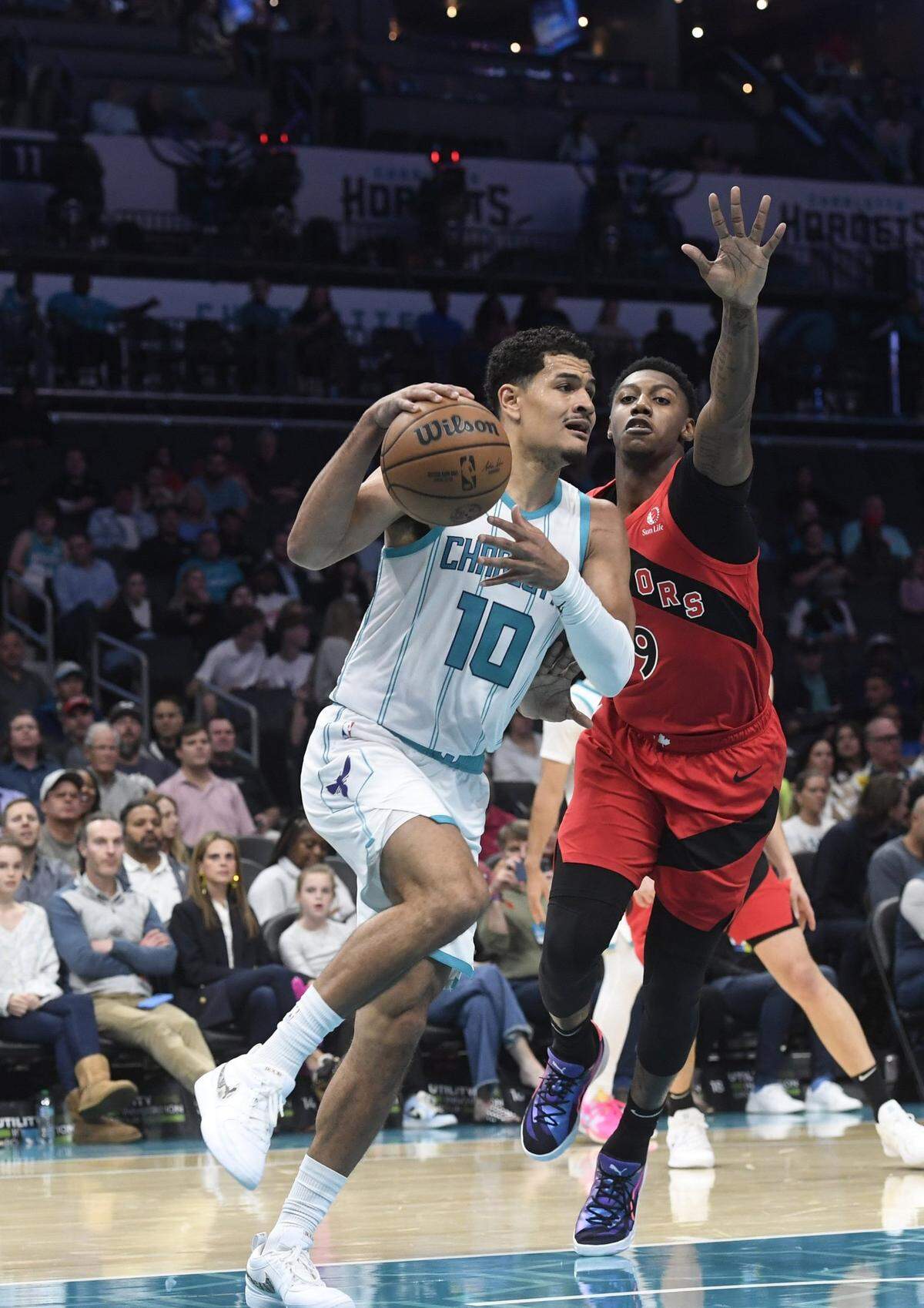 Oct 30, 2024; Charlotte, North Carolina, USA; Charlotte Hornets guard Josh Green (10) drives past Toronto Raptors guard forward RJ Barrett (9) during the first half at the Spectrum Center. Mandatory Credit: Sam Sharpe-Imagn Images