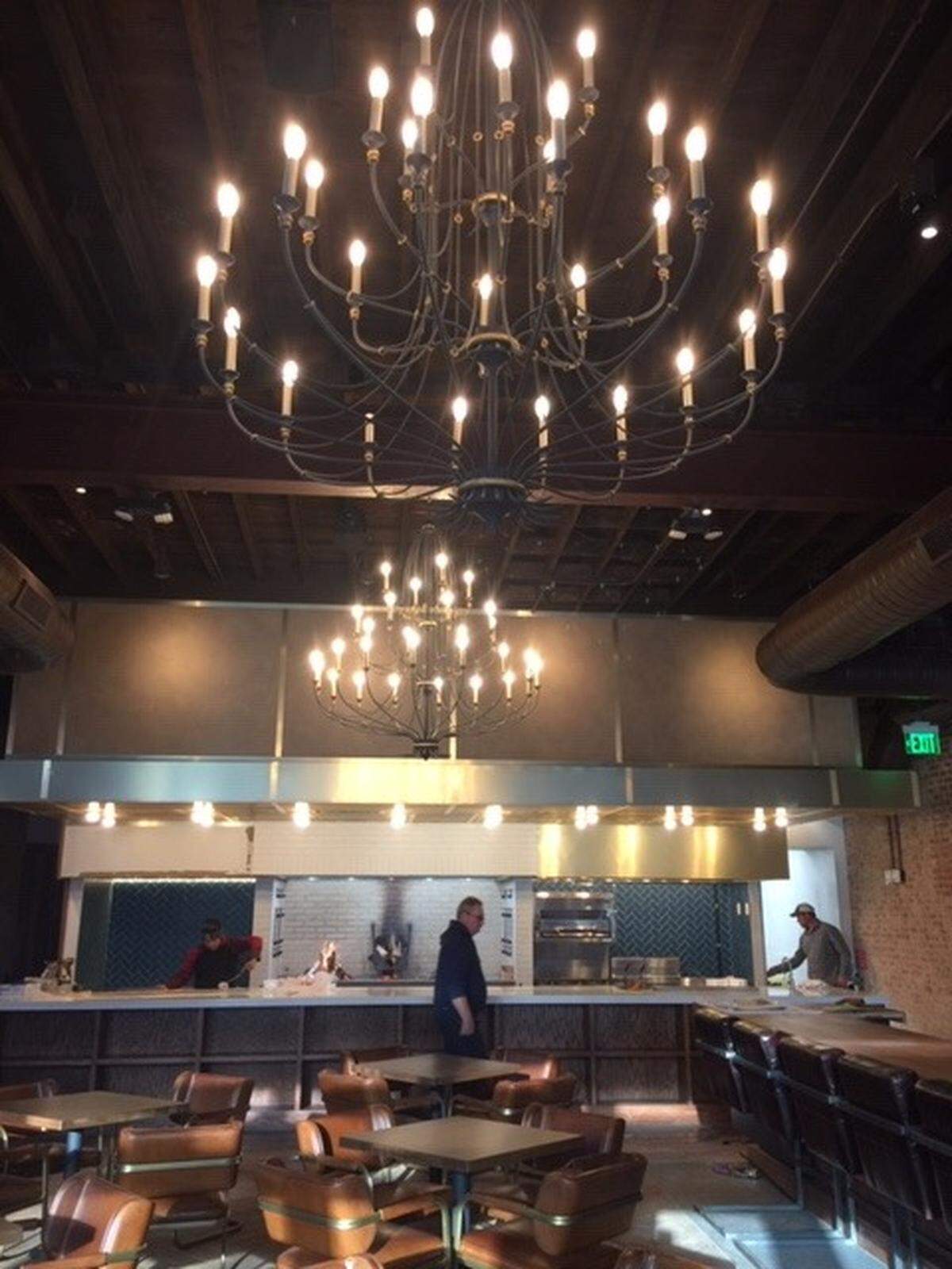 The Crunkleton features two dramatic chandeliers, a long oak bar along the side, and an open kitchen across the back centered in a large wood-fired fireplace. Finishing touches were being put into place on Wednesday.