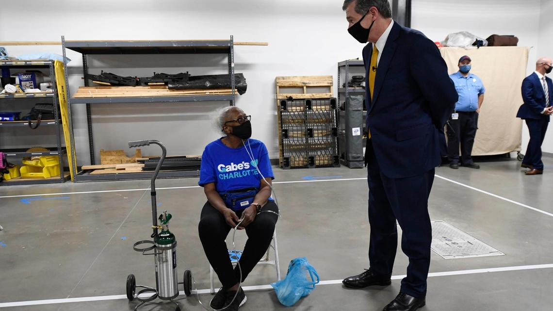 N.C. Gov. Roy Cooper talks to a COVID vaccine recipient during a tour of the Mecklenburg County Vaccine Site at MEDIC Clinic n Wednesday, May 5, 2021.