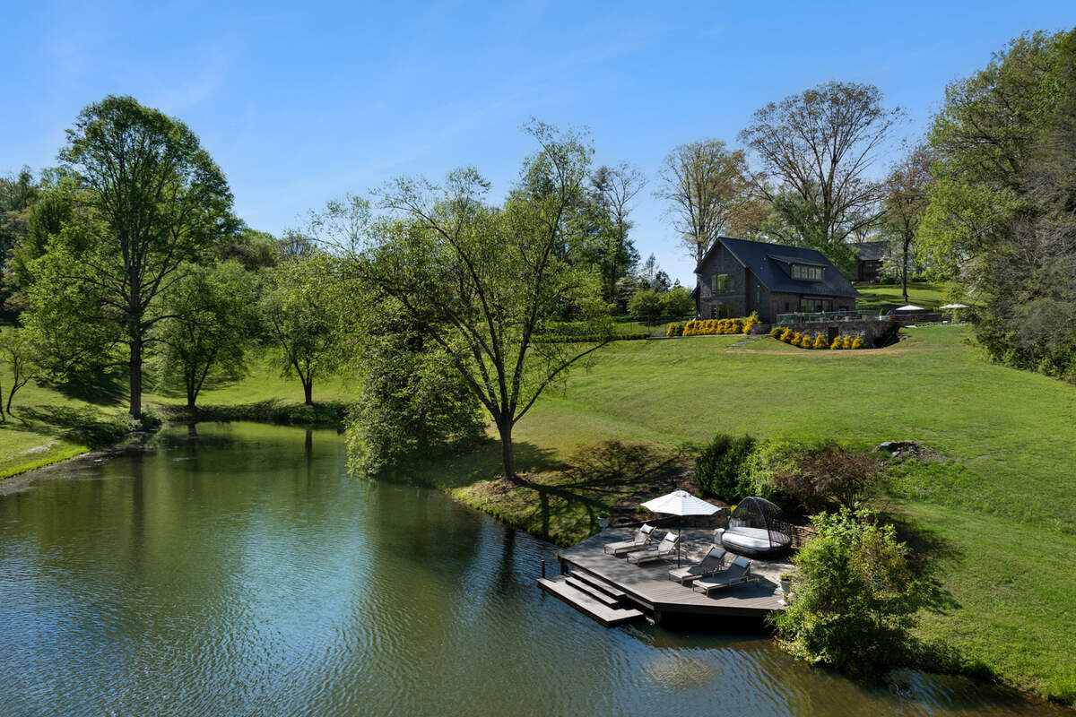 A drone shot of one of the ponds captures one of the guest cottages overlooking a pond.