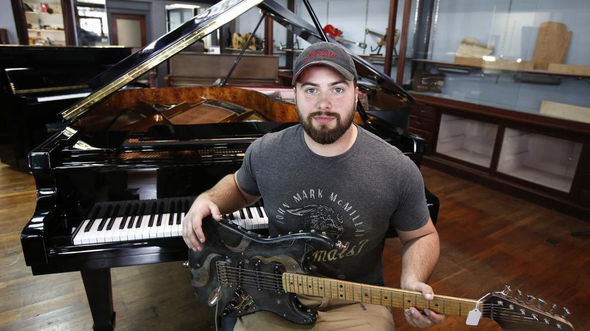 Jonathan Levister at his new music store and custom guitar making operation in Chester, Experience Custom Shop. Levister holds the first guitar he made.