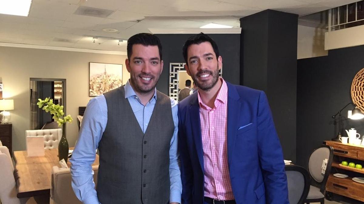 Jonathan (left) and Drew Scott, best known as HGTV’s “Property Brothers,” stand in a showroom full of furniture from their Scott Living line during a visit to High Point Market. The two are here to meet with members of the national furniture industry and give a talk to industry professionals.